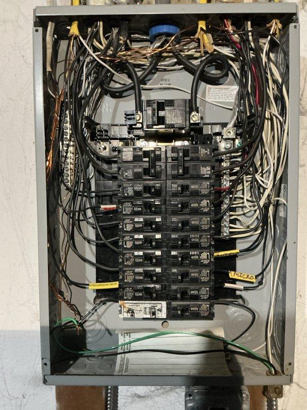 Responded to service call for outlet repair at residential property. Upon arrival, conducted comprehensive electrical system inspection and documented existing electrical panel configuration. Panel examination revealed organized circuit breaker arrangement with properly labeled circuits including dedicated lines for air conditioning, kitchen GFCI outlets, washer outlet, refrigerator, island circuits, bathrooms, bedrooms, and basement room. Verified all circuit breakers were functioning correctly, connections were secure, and wire bundling was properly maintained with appropriate cable management. Inspected grounding system and main disconnect switch for proper operation. Photographed panel interior showing wire routing, color-coded conductor organization, and circuit identification labels for service documentation. All electrical components found to be in safe operating condition with no immediate hazards identified.