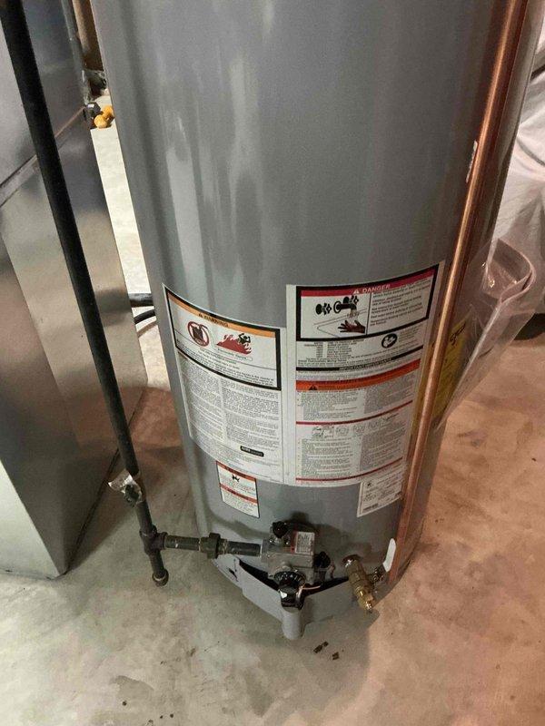 Installed 50-gallon tall gas water heater in residential basement utility area. Completed all plumbing connections including copper supply lines, shut-off valves, and brass fittings at tank base, with proper gas line installation using black iron pipe. Unit set up for delivery with St. Louis County permit #26PLU-19532, plumbing ID sticker applied per county requirements.