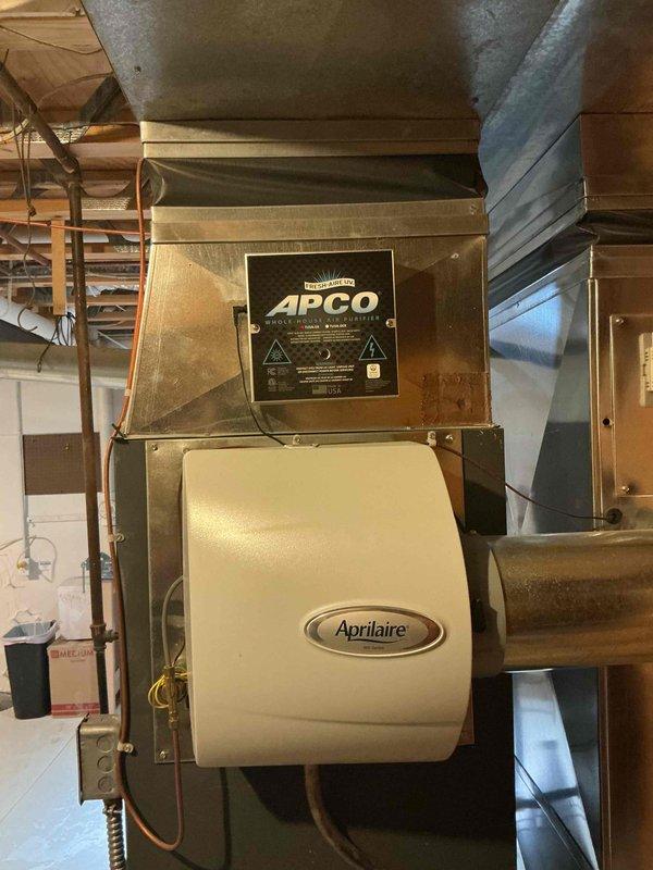 # O10 Tune-Up Completed - Single AC Unit

Performed comprehensive tune-up service on a 10-year-old residential air conditioning system located in basement utility room. Conducted full system inspection of furnace/air handler unit with integrated Aprilaire humidifier and APCO air purification system. Verified proper operation of all components, inspected ductwork connections and metallic supply/return runs for secure mounting and adequate sealing. Checked electrical connections at junction box, examined copper refrigerant lines for integrity, and assessed overall system performance. Cleaned accessible components, confirmed humidifier functionality, and documented equipment condition with photographic records. System operating within normal parameters with no immediate repairs required at time of service.