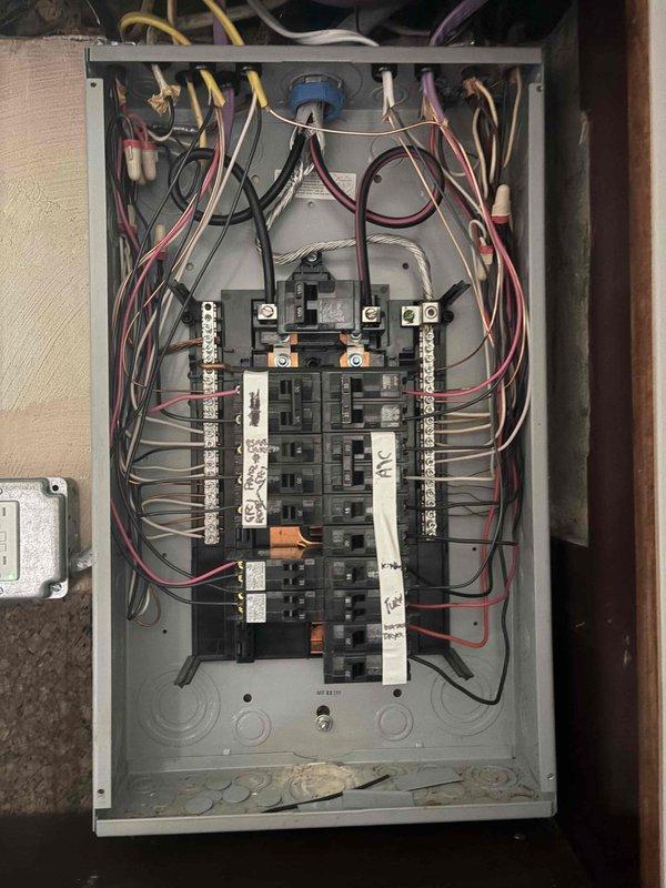 Conducted comprehensive electrical assessment for converting two-prong ungrounded outlets to three-prong grounded receptacles throughout the residence. Inspected main electrical panel to verify grounding system integrity, evaluated existing circuit breaker configuration, and assessed bus bar connections and grounding conductor pathways. Documented current electrical infrastructure including surface-mounted conduit runs and existing receptacle locations to determine scope of work required for proper grounding installation and code compliance upgrades.