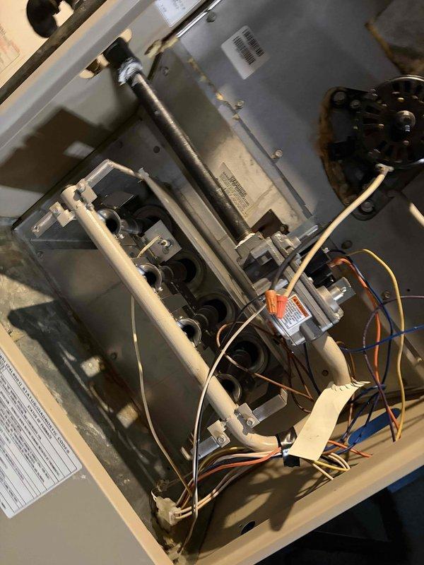 Completed comprehensive tune-up service on a 30-year-old furnace located in basement. Performed full system inspection with access panel removed, examining gas valve assembly, burner array, heat exchanger, and all internal components. Verified proper electrical connections and measured operating amperage at 12.2 amps using clamp meter, confirming system is drawing within normal parameters. Inspected blower motor assembly, gas piping, wiring harnesses, and safety controls for proper operation and wear. All components found to be functioning adequately for the unit's age, with typical dust accumulation and minor surface wear consistent with three decades of operation. System operational and safe for continued use.