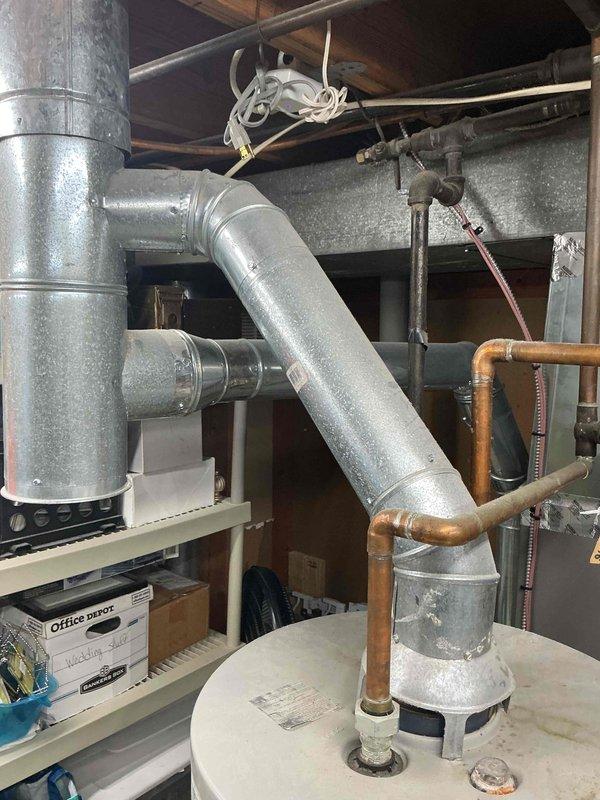 Completed installation of 50-gallon tall gas water heater in basement utility area. Performed all necessary plumbing connections including supply and discharge piping, gas line hookup, and proper venting to existing ductwork. Applied required permit identification sticker per permit #26PLU-20085 and verified all connections meet code requirements for safe operation.