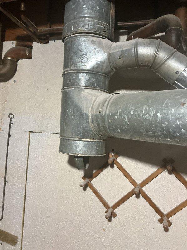 Performed a heating tune-up on a single Lennox Elite Series upflow gas furnace, inspecting the cabinet, flue venting, condensate/drain line, gas and electrical connections, and the supply ductwork and fittings for proper operation. Verified the unit and associated galvanized duct and flue components were in serviceable condition, and noted minor rust staining on the surrounding floor for monitoring.
