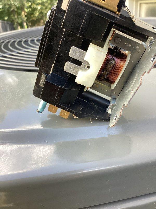 Diagnosed a no-cool, unresponsive condition on a 3-year-old split AC system and found the condenser contactor failed, with a burnt, charred coil winding and corrosion on the mounting brackets. Replaced the failed contactor, restored control voltage to the condenser, and verified the system returned to normal cooling operation.