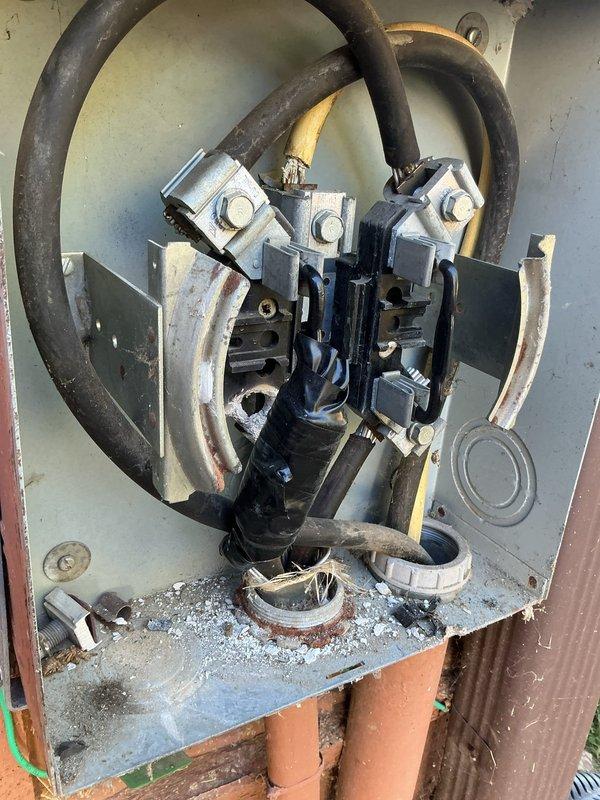 Evaluated the exterior meter socket for replacement of three lugs per utility specifications. Inspection revealed corroded meter jaw brackets, heat discoloration and debris within the enclosure, a rusted conduit opening with frayed conductor strands, and taped conductor splices, indicating the socket requires further repair or replacement beyond lug replacement. Documented existing conditions for estimate preparation.
