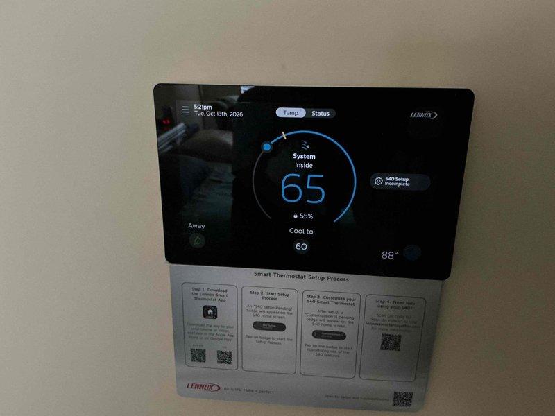 Responded to a non-responsive thermostat complaint on a two-unit system and inspected the Lennox S40 smart thermostat. The blank display was resolved and the unit is now powering on and showing normal system status, though the thermostat setup remains incomplete and requires finalizing through the manufacturer's setup process.