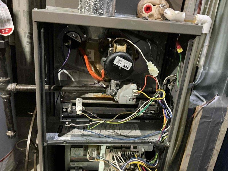 Performed a seasonal tune-up on a single gas furnace, including removal of the front access panel and inspection of the inducer motor, gas valve assembly, burner compartment, blower motor, control board, and low-voltage wiring. Verified gas manifold pressure with a digital dual-port manometer, with readings near 3.5 inWC. Noted surface rust on the gas valve and adjacent components, along with loosely bundled wiring in the burner compartment, and recommended monitoring these conditions during future maintenance.