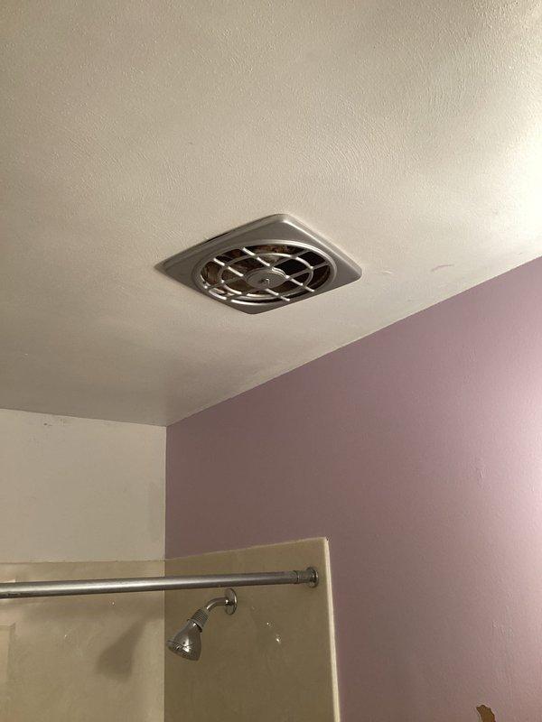 Installed a new bathroom exhaust fan in the ceiling, replacing the existing fan housing that was clogged with dust and debris. Secured the unit flush to the textured ceiling, completed the electrical connections, and tested the fan for proper operation and airflow.