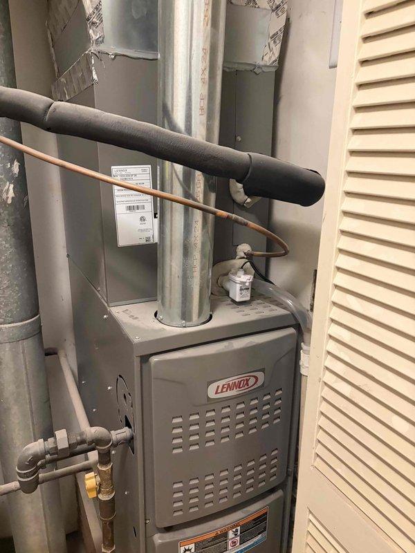 Performed a seasonal tune-up on a 2-year-old Lennox gas furnace, inspecting the inducer motor, pressure switch and hose, gas valve and piping, burner and heat exchanger area, and control wiring and connections. Verified electrical operation with a clamp meter, checked the condensate drain and vent piping, and confirmed all components were in good working order with no visible damage, rust, or leaks. System was reassembled and left operating normally.
