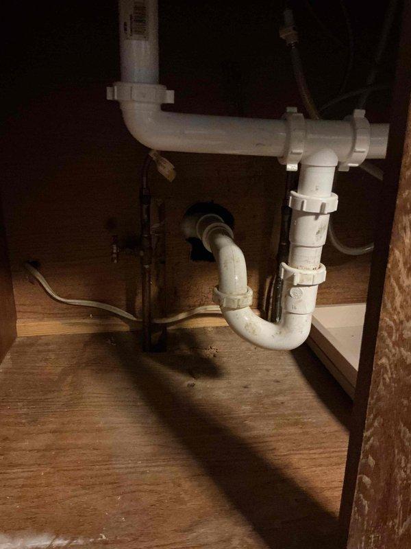 Responded to a clogged double-basin kitchen sink and inspected the under-sink PVC drain assembly, including the slip-nut joints and P-trap, for restrictions. Cleared the blockage from the drain line, restoring free flow, and verified proper drainage from both basins with sustained running water and no leaks at the trap connections.
