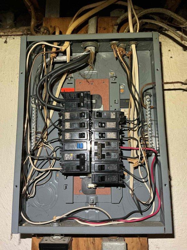 Inspected the non-functioning electrical service panel and found disorganized, loosely routed conductors with mixed legacy cloth-insulated and newer cable types, indicating the unit is at end of service life. Recommended full panel replacement with proper conductor routing, labeling, and neutral/ground bus termination to restore safe, code-compliant operation.