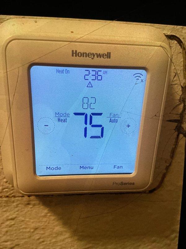 Performed a seasonal tune-up on one 9-year-old gas furnace, including inspection of the unit and verification of operation in heat mode. Inspected the return air filter and confirmed proper airflow components. Verified thermostat communication and operation, noting a wireless signal fault indicator and cracking in the wall surface around the thermostat mounting.