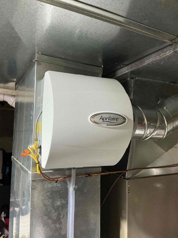 Performed seasonal heating maintenance on the furnace and replaced the 20x25x4 pleated air filter with a new one. Inspected the Aprilaire whole-home humidifier mounted on the supply duct, verifying the duct connection, wiring, water supply tubing, and drain line were intact and free of leaks, cracking, or corrosion. System left operational with no deficiencies noted.