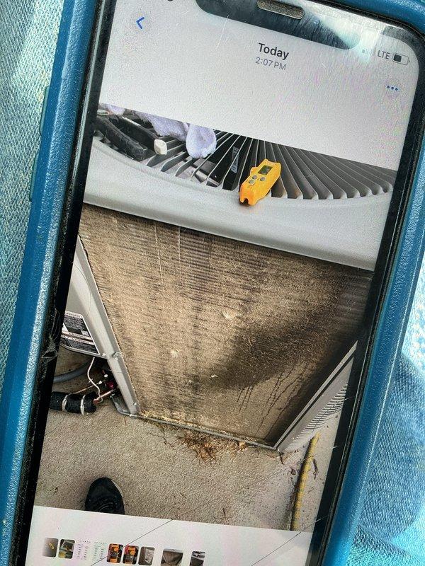Performed a cooling tune-up on a single residential split system (under 10 years old). Inspected the air handler and found the pleated return air filter loaded with dust and debris. Evaluated the outdoor condenser, which showed heavy dirt and grime buildup on the coil surface along with accumulated leaves and organic debris at the base. Took system performance measurements with a digital meter at the condenser to verify operation and documented unit conditions with photos.