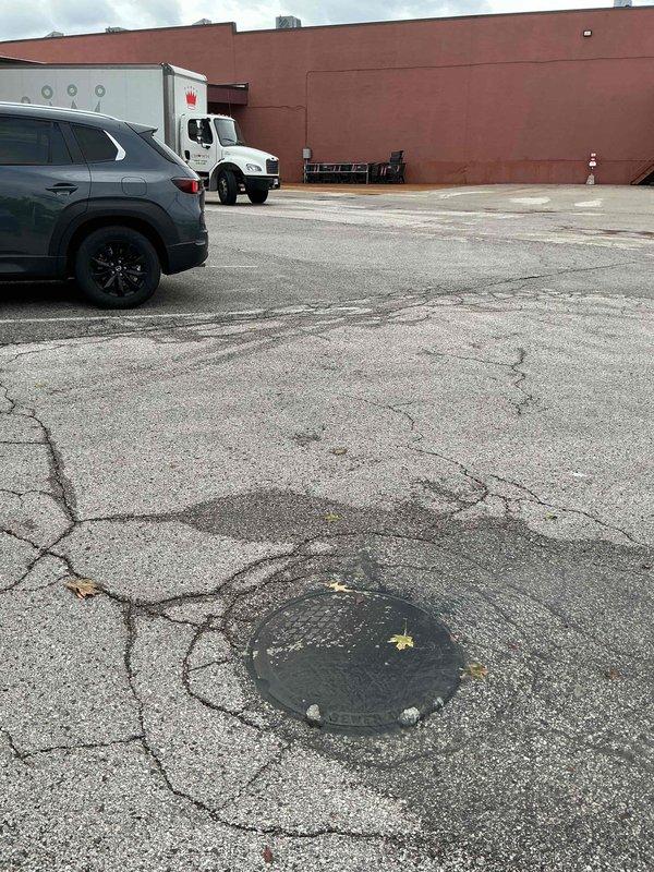 Responded to a reported sewer vent pipe backup and inspected the exterior sewer cleanout and surrounding drain line, where wastewater was surfacing and running across the pavement. Evaluated the main sewer line for blockage and restricted flow, with the cracked, deteriorated pavement around the access cover noted as a possible contributing factor. Documented site conditions with photos for follow-up recommendations.