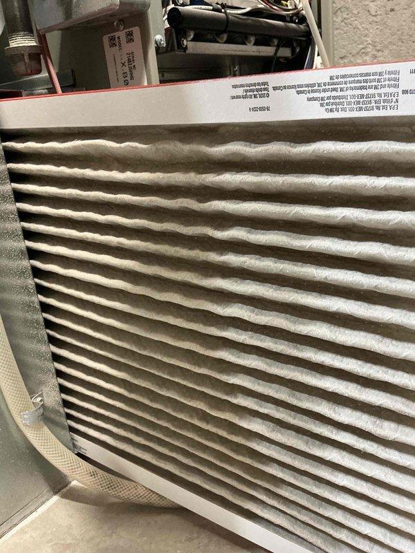 Performed a seasonal tune-up on the furnace, including inspection of the unit and its components. Found the pleated air filter heavily loaded with dust and debris, indicating it is due for replacement to maintain proper airflow and efficiency. Verified thermostat operation and confirmed the system responded to its call.