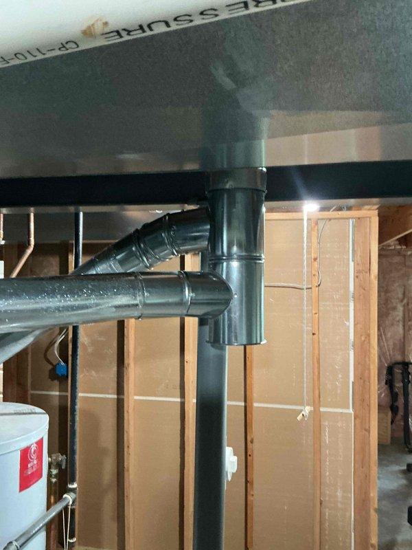 Replaced the galvanized flue tee (5"x4"x5") in the vent connector assembly serving the gas appliances, ensuring secure, properly sealed joints and correct flue alignment to the vertical vent. Verified the new fitting was fastened and supported so combustion byproducts exhaust safely through the venting system.