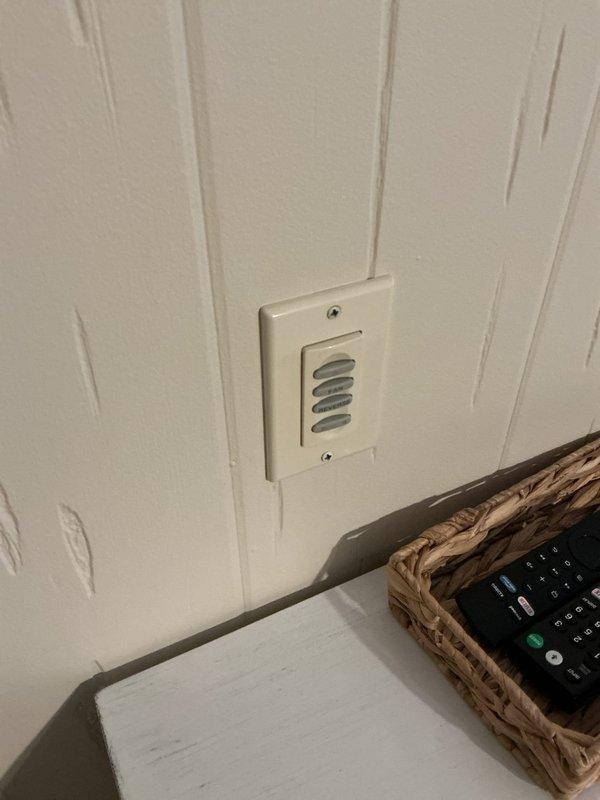 Performed an on-site evaluation for an electrical fixtures estimate, including assessing a room with no existing lighting to determine wire routing from the unfinished basement ceiling joist cavity, inspecting non-functioning light fixtures in a second room, and reviewing a multi-button fan control wall plate along with a dimmer switch slated for removal. Scope of work was documented with photographs to support the proposed installation of new lighting circuits, troubleshooting of the inoperative fixtures, and dimmer switch uninstallation.