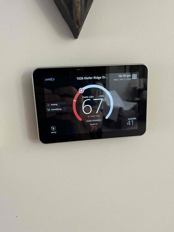 Performed a seasonal tune-up on a 5-year-old vertical gas furnace, removing the front access panel to inspect the burner assembly, gas valve, and control compartment. Found the return air filter heavily clogged with debris, which restricts airflow and reduces heating efficiency. Verified the Lennox smart thermostat was operating properly in heat mode with the humidifier engaged, and cleaned up the work area with a cordless vacuum upon completion.