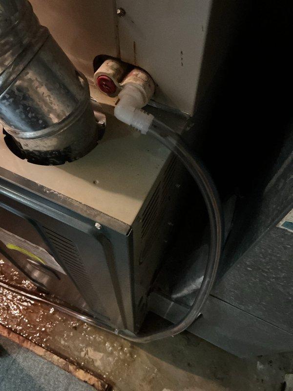 Responded to a water leak complaint on a single gas furnace and inspected the unit, finding standing water on the floor, rust staining at the vent and pressure switch tubing area, and mineral deposits on the blower housing, indicating condensate or moisture intrusion. Documented all affected components and conditions for evaluation of condensate drain, trap, and flue vent integrity.