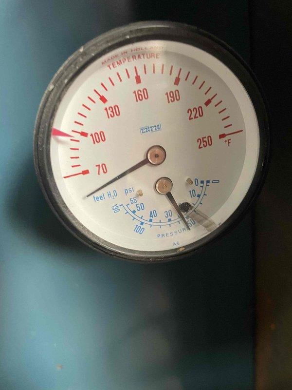 Responded to a no-heat call on a boiler that made loud noises and began leaking after the water supply was shut off and restored. Inspected the unit and found heavy corrosion and mineral buildup on the supply and return piping, valves, and fittings, with the temperature/pressure gauge reading low system pressure and temperature. Documented the system condition and leak points with photos for repair evaluation.