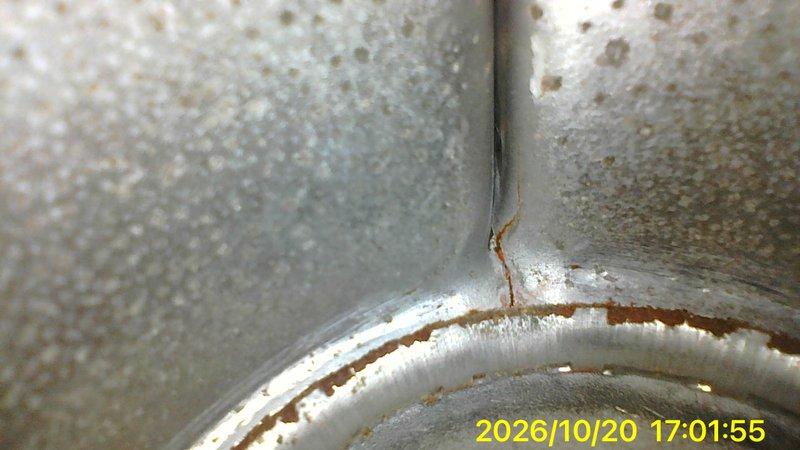 Responded to a no-heat call on a 10+ year-old basement furnace that would not start. Inspected the flue/vent piping and found corrosion along the seam and collar, with rust streaking and a possible hairline crack that could compromise safe venting. Also noted heavy dust and grime buildup around the unit's housing and penetration, and documented both conditions with photos for repair evaluation.