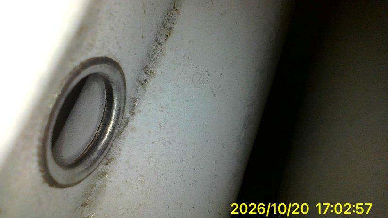 Responded to a no-heat call on a 10+ year-old basement furnace that would not start. Inspected the flue/vent piping and found corrosion along the seam and collar, with rust streaking and a possible hairline crack that could compromise safe venting. Also noted heavy dust and grime buildup around the unit's housing and penetration, and documented both conditions with photos for repair evaluation.