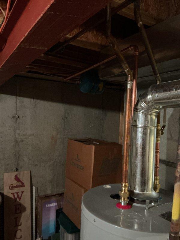 Installed a new 40-gallon tall gas tanked water heater, connecting copper hot and cold supply lines with brass fittings and a galvanized flue with proper elbow and upward pitch to the existing vent. Existing expansion tank and overhead supply piping were reconnected, and the installation was completed in accordance with municipal permit requirements.