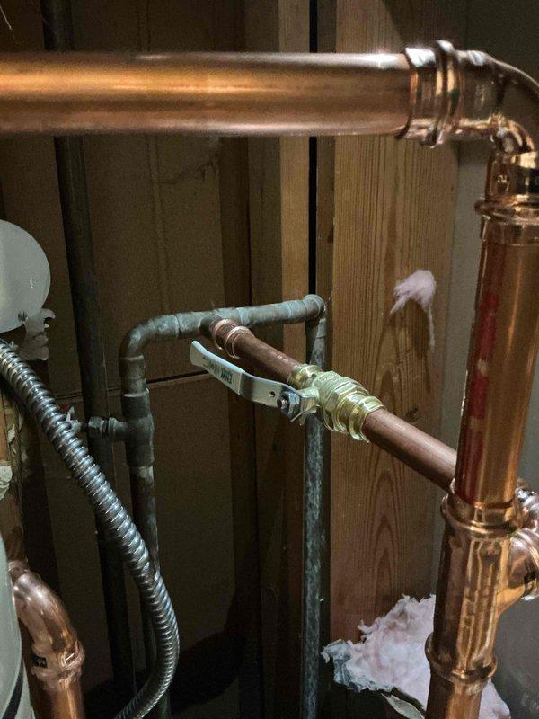 Responded to a call-back for a minor drip at a water supply connection on a recently installed 30-gallon gas lowboy water heater. Inspected the new copper press-fitting supply piping, brass ball valve, and transition to existing galvanized pipe, as well as the flexible connector, to identify the leaking hookup. Verified the connections were secure and watertight, with no active leaks remaining and the installation operating as intended.