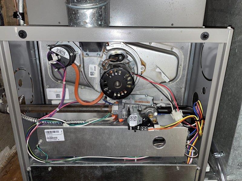 Performed a heating tune-up on a gas furnace, inspecting the inducer motor, pressure switch and tubing, gas valve, burner assembly, flue connection, and wiring harnesses. Noted light discoloration and rust staining around the inducer motor housing for monitoring. Inspected the 20x25x1 pleated return air filter, which showed dust loading, and verified the system was operating properly at completion.