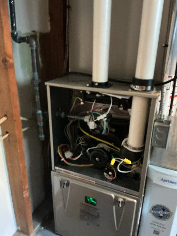 Performed a heating tune-up on one 1-year-old gas furnace, removing the upper access panel to inspect the control wiring, blower and inducer motor assembly, and electrical connections, and verifying the PVC intake/exhaust piping and coupling were secure. Confirmed the furnace operated properly through the heating cycle with the thermostat responding to calls for heat, and checked the gas piping connections and adjacent AprilAire unit for normal condition. Reinstalled all panels and left the system running properly.
