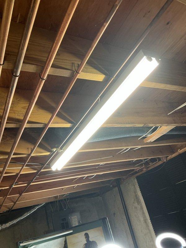 Replaced existing basement light fixtures with new linear LED fixtures mounted to the exposed floor joists, securing them in place and reconnecting to the existing branch circuit wiring. Verified proper operation and illumination of all installed fixtures, and tidied loose cabling along the joists to ensure a clean, code-compliant installation.