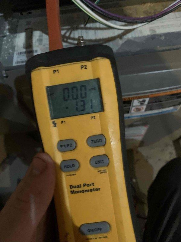 Responded to a no-heat call on an approximately 4-year-old Goodman furnace and inspected the cabinet, pressure switch, and related wiring and hose connections. Used a dual-port manometer to measure pressure at the pressure switch circuit, recording a negative pressure reading of -1.31 in. w.c., to evaluate draft inducer operation and verify proper switch function.