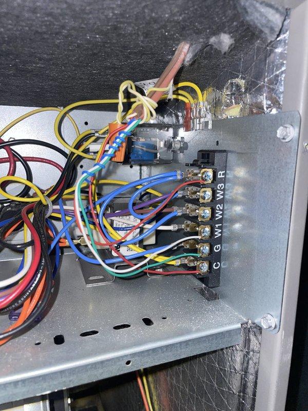 Responded to a no-power complaint on a newly installed ecobee smart thermostat. Inspected the thermostat and the low-voltage terminal strip at the air handler, which showed terminals C, G, W1, W2, W3, and R with dense, disorganized control wiring and no visible burn marks or damage. Evaluated the 24V control circuit and thermostat wiring, including the C-wire connection, to determine the cause of the power loss.
