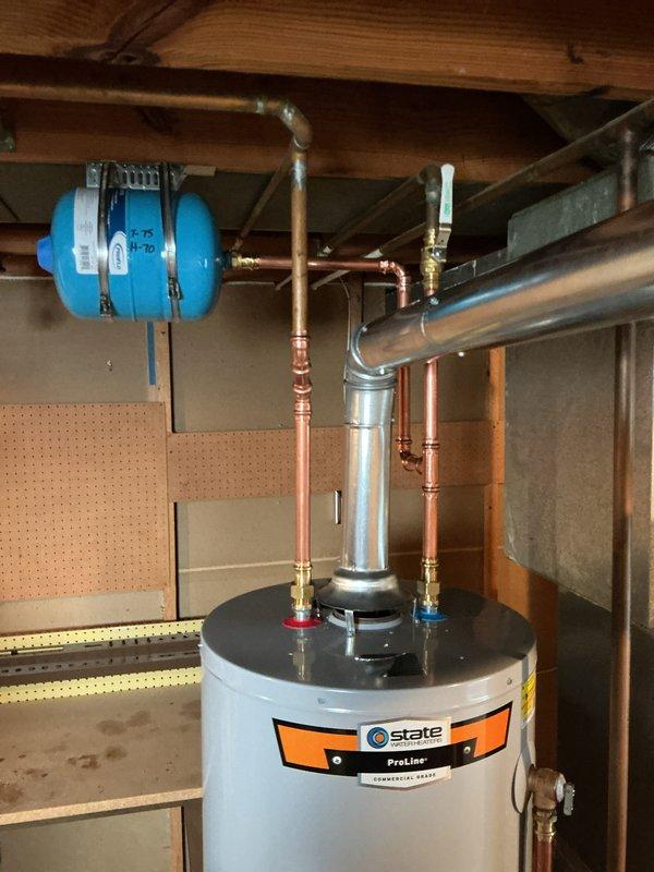 Installed a new 40-gallon tall natural gas State ProLine water heater, connecting new copper supply piping with soldered fittings, a 3/4" temperature and pressure relief valve, and a shutoff valve. Mounted an expansion tank to the supply line, reconnected the gas line, and routed the galvanized flue to the existing vent system. Verified the installation is clean and leak-free with no visible corrosion.