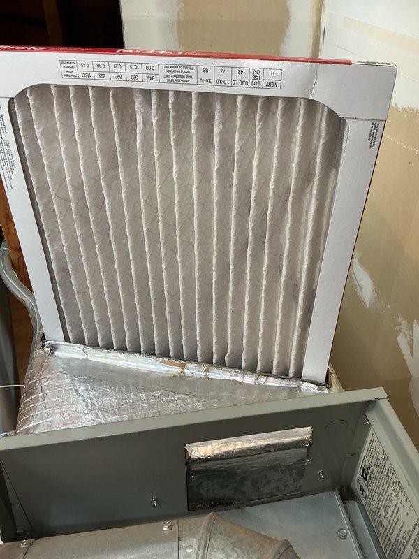 Performed seasonal heating tune-ups on two furnaces, inspecting the electrical and control compartments and verifying operating amperage with a true RMS clamp meter. Inspected the air filters, noting heavy dust and debris loading with a torn frame on one, and found damaged foil-faced insulation and tape at the cabinet opening; recommend filter replacement and repair of the cabinet insulation and seal to maintain proper airflow and prevent air leakage.