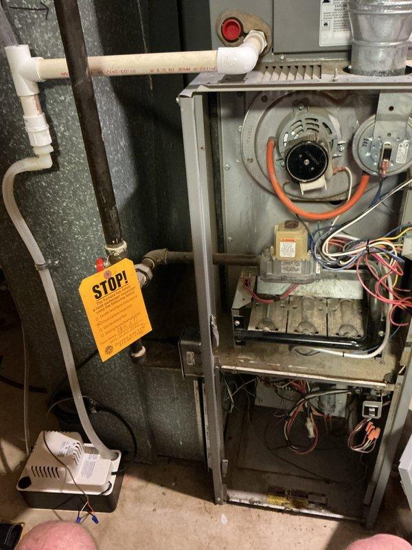 Responded to a no-cool call on a single unit that was not starting and producing a clicking noise. Inspected the gas furnace with the access panel removed, evaluating the inducer motor assembly, pressure switch and wiring, gas valve, burner assembly, control wiring, and condensate drain line and pump. A red-tagged ("STOP!") gas line was noted at the furnace gas supply, and the unit remains subject to the tag's restrictions pending any required corrective repairs.