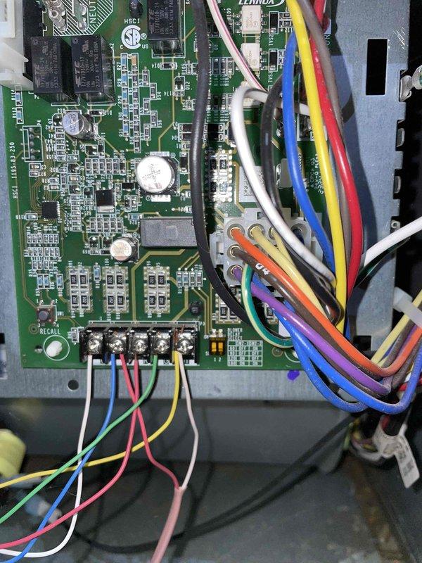 Responded to a no-heat call for a burning odor from a Lennox furnace installed in a crawlspace. Inspected the furnace control cabinet and integrated control board, including terminal block connections and low-voltage wiring harness, and found no evidence of burn marks, corrosion, overheating, or damaged conductors. System was found shut off by the homeowner; the cause of the odor was not conclusively identified from visual inspection of the control board and wiring.