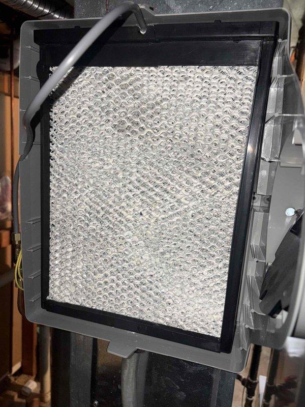 Performed a seasonal heating tune-up on a 15-year-old furnace, inspecting the cabinet, ductwork, and associated components and confirming the system was operating properly. Replaced the 20x25x1 pleated air filter and inspected the whole-house humidifier, noting heavy mineral scale buildup on the water panel that will need replacement or cleaning for proper humidification. System left in working condition.