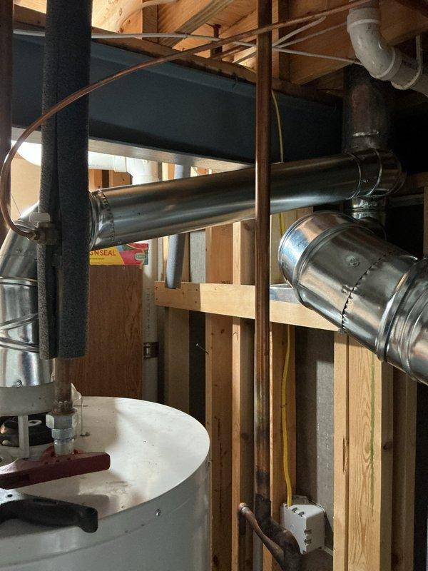 Repaired the flue venting by replacing the 5"x4"x4" flue tee, a 10' length of 4" flue pipe, and a 5"x4" elbow, then secured the connections with hose clamps. Removed the old components and verified the flue run was properly joined and supported for safe exhaust.