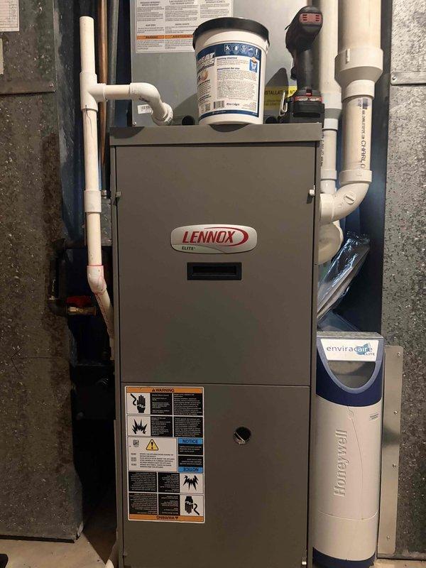 Performed a heating tune-up on a Lennox Elite gas furnace, inspecting the cabinet, PVC condensate and venting, and the Honeywell EnviraCaire unit for leaks, corrosion, and damage, with none found. Flushed the condensate drain through the clean-out port, confirming proper drainage with a clear, unobstructed flow. The system was operating correctly at completion.