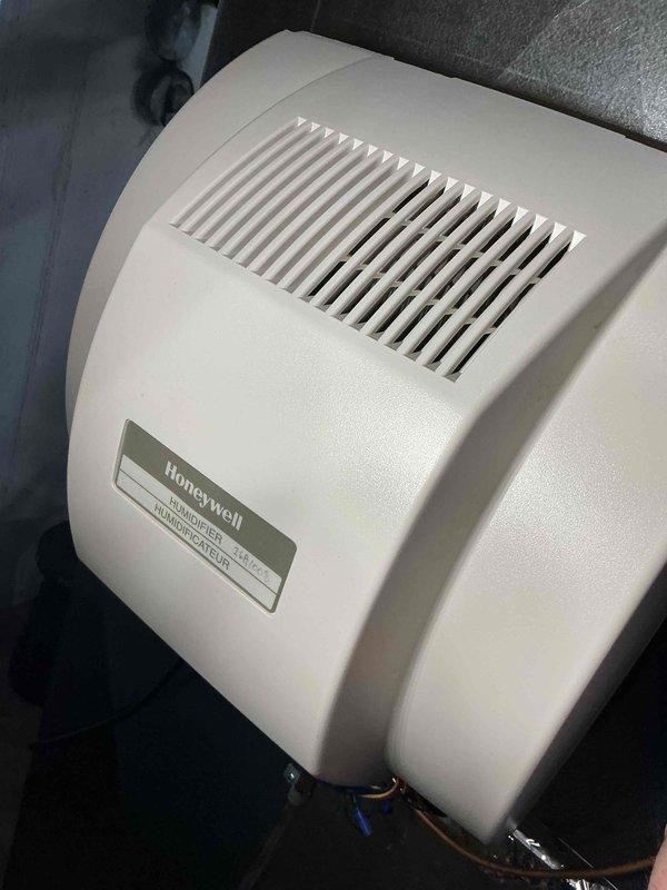 Performed a seasonal tune-up on a 4-year-old gas furnace serving a single-unit system. Removed the dust-loaded and discolored 20x25x1 pleated return air filter and installed a new replacement filter. Inspected the Honeywell whole-home humidifier and found the housing clean and intact, with no visible rust, cracks, or damage.