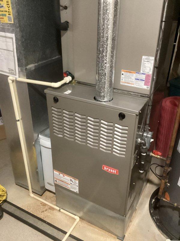 Performed a heating tune-up on a 10-year-old Bryant gas furnace, inspecting the cabinet, flue piping, gas connections, and PVC condensate drain for proper installation, leaks, and corrosion, with none found. Removed and inspected the flame sensor, which showed carbon buildup on the rod, and cleaned it to restore reliable flame sensing. The system was confirmed to be operating properly at the time of service.