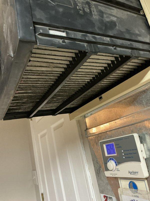 Performed a heating tune-up on one unit, including inspection of the galvanized supply ductwork and connections, with no signs of damage, corrosion, or frost noted. Inspected the media air cleaner and found the pleated filter heavily loaded with dust and debris, indicating it is due for replacement. Verified the Aprilaire control unit is operational with its display and indicator lights functioning.