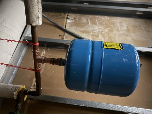 A new expansion tank was installed to manage water pressure fluctuations, ensuring the system's longevity and efficiency. This involved precise placement and securing the tank with a sturdy strap to maintain stability. Additionally, an antisiphon vacuum breaker was installed on the water heater. This critical component prevents backflow, safeguarding the water supply from contamination. The installation process required careful attention to detail, ensuring all connections were secure and functioning correctly. The system is now better equipped to handle pressure changes and maintain water quality.