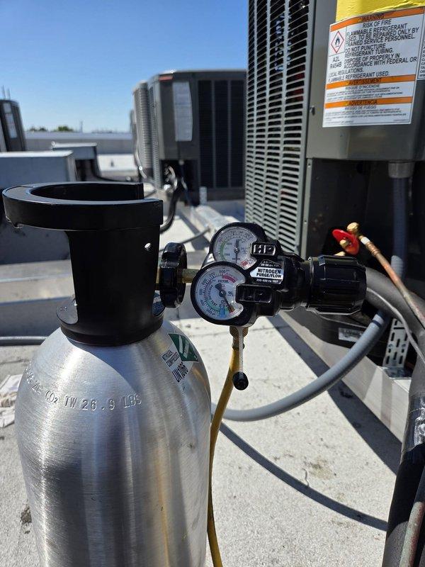 Charleston, SC - Performed leak test on rooftop HVAC unit using refrigerant gauge manifold and electronic leak detector, documenting pressure readings of 207 PSI and 227 PSI during diagnostic evaluation. Inspected condensing unit components and identified areas requiring repair, capturing photographic documentation of equipment condition for estimate preparation.