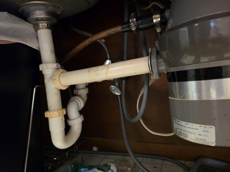 Isle of Palms, SC - Conducted on-site evaluation of existing garbage disposal unit, which is over 10 years old and showing signs of wear and deterioration. Inspected the mounting assembly, electrical connections, and drainage configuration beneath the kitchen sink. Documented the current plumbing setup, including the P-trap arrangement, PVC drainage pipes, and connection points to the sink strainer. Photographed significant internal corrosion and mineral buildup within the disposal's discharge pipe, indicating reduced efficiency and potential for future failure. Assessed the cabinet space, existing electrical wiring, and mounting hardware to determine compatibility requirements for replacement unit. Provided comprehensive estimate for garbage disposal replacement, including removal of existing unit and installation of new disposal with proper mounting, electrical connection, and integration with existing drainage system.