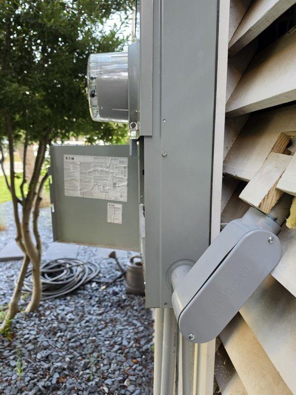 Completed HVAC system installation for in-law suite including kitchen and laundry area. Installed exterior condenser unit on concrete pad with proper gravel base, mounted electrical disconnect box and weatherhead service entry on exterior wall per code requirements. Ran electrical wiring through interior crawlspace to connect new HVAC equipment to main electrical panel, ensuring proper wire routing and support through confined utility space.