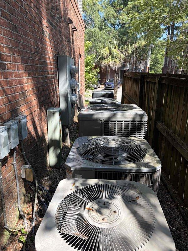 Conducted site assessment for replacement of 20 HVAC units across multifamily property locations. Inspected existing condensing units at first property, documenting multiple outdoor installations including units positioned on wooden platforms and along building exterior walls. Evaluated electrical disconnect boxes, conduit routing, and existing pad conditions. Initial site visit completed in preparation for comprehensive replacement quote, with second property location to be assessed following customer coordination.