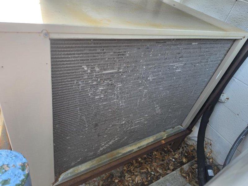 Responded to report of non-functional freezer unit. Upon arrival, inspected outdoor condensing unit and indoor evaporator coil assembly. Found condensing unit exterior coil heavily obstructed with accumulated leaves, dirt, and organic debris along base and lower sections, restricting airflow and reducing heat transfer efficiency. Removed debris from condenser coil and surrounding area. Inspected indoor evaporator coil assembly mounted to ceiling, verified electrical connections at junction box, and confirmed proper wiring integrity. Checked refrigerant lines and flexible ductwork for damage or disconnections. Unit restored to normal operation with improved airflow through cleaned condenser coil.